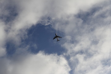 Naklejka na ściany i meble airplane in the sky within clouds