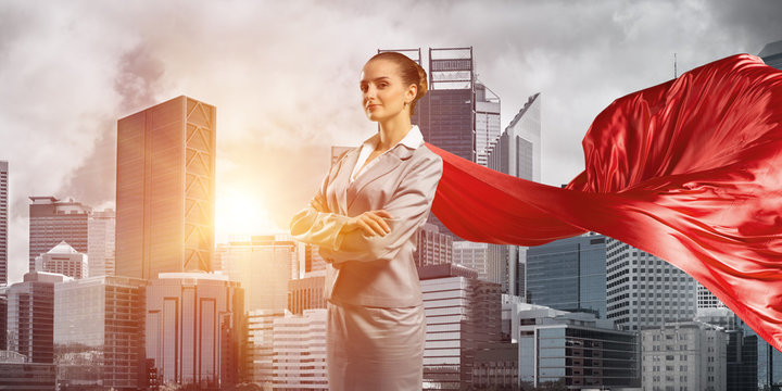 Concept of power and sucess with businesswoman superhero in big city