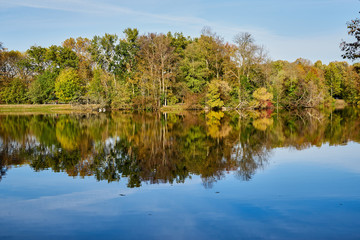 Fototapeta na wymiar Herbstliches Panorama mit heller Sonne und Spiegelungen im Karpfenteich in Berlin im Treptower Park