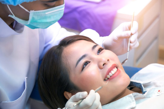 Asian dentist and the patient are preparing to treat carious teeth in the dental clinic