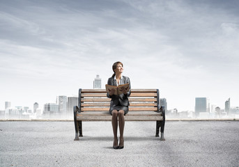 Young woman holding open book on wooden