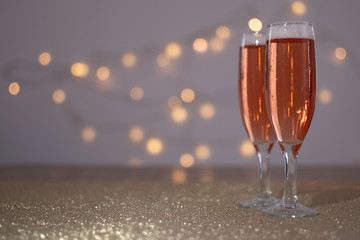 brindis de dos copas de champaña con luces de fondo
