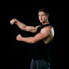 Muscular model young man on isolated black background. Sport workout bodybuilding Fitness concept. Strong bodybuilder brawny posing.