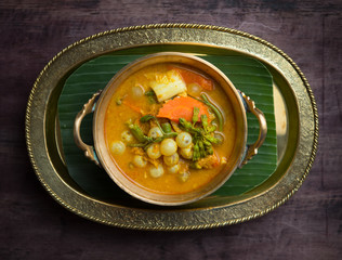 Sour curry soup with spawn and green vegetable on black wooden table,Thai food