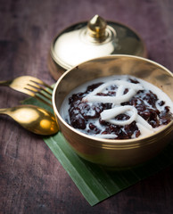 Black sticky rice with coconut milk on wood,Thai dessert