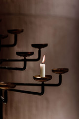 candle burns in the rustic candlestick. candle in church