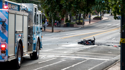 Wrecked motorcyle  in front of firetruck and laying on the road after exploding in accident