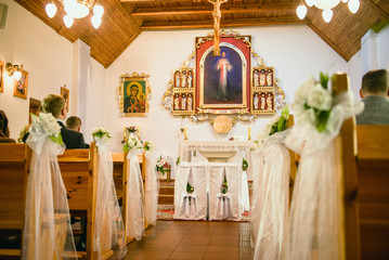 Church sanctuary before a wedding ceremony. Empty chairs for bride and groom.