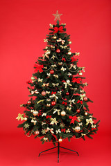 Christmas fir tree with ornaments on red background