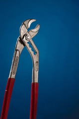 Working tool, pliers on a bright blue background.