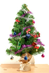 Green Christmas tree decorated with gifts And white background