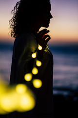 Romantic life concept with standing lady and yellow bulb romance light - defocused natural outdoor...