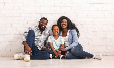 Joyful Afro Family With Little Daughter Sitting On Floor Together