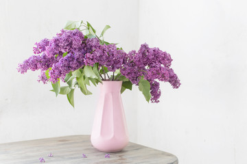 lilac in vase on background old white wall