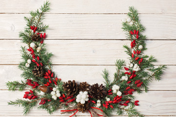 Fototapeta na wymiar Christmas wreath on white wooden backdrop