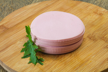 Sliced sausage over the wooden board
