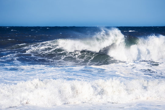 Big blue ocean wave crashing near the coast. Beautiful nature background © smallredgirl