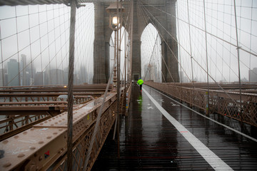 runner in Brooklyn bridge under the rain