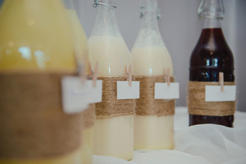 Bottle of cold vodka and wine bottle in bucket with ice and orange juice in jug on table, copy space. Alcohol bottles in ice bucket in restaurant. Wedding party.