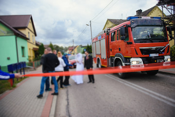 Beautiful wedding couple on outdoor photoshoot with fire truck.