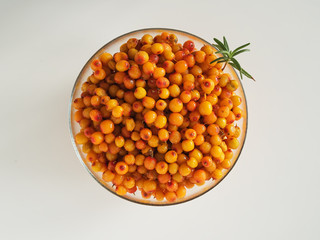 Glass cup with sea buckthorn berries on a white background. Top view. Ingredients for Herbal Tea.