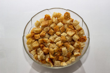 Crackers or croutons of homemade white bread close-up in a glass plate. Texture of slices of dry rye bread.
