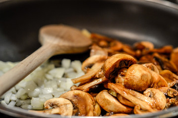 Onions and mushrooms on a frying pan