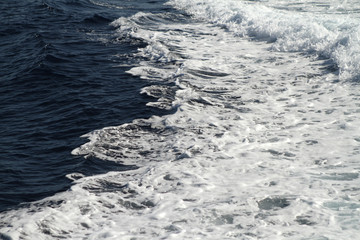 Weisser Schaum und Wellen auf der Wasseroberfläche im Meer. Gischt am Ozean bei einer Fahrt mit dem Schiff. Wasser in Bewegung. Kiel