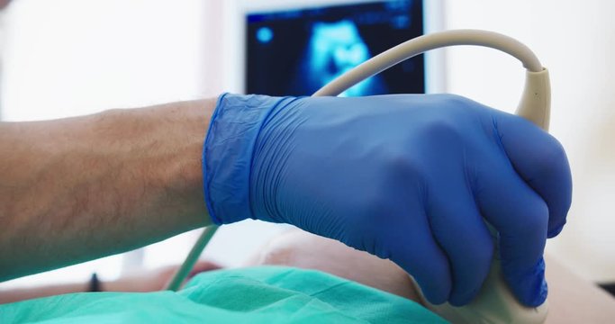 pregnant woman getting her ultrasound, see her baby in her stomach in the hospital with a doctor