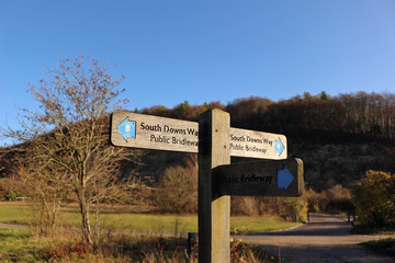 A signpost between Butser Hill and Queen Elizabeth Country Park in Hampshire pointing to the South Downs Way, a long distance footpath and bridleway running along the South Downs in southern England.