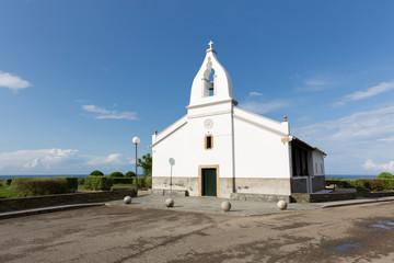 Fototapeta na wymiar Ermita de color blanco con intenso cielo azul situada en el Cabo de San Agustín en Ortiguera, Asturias
