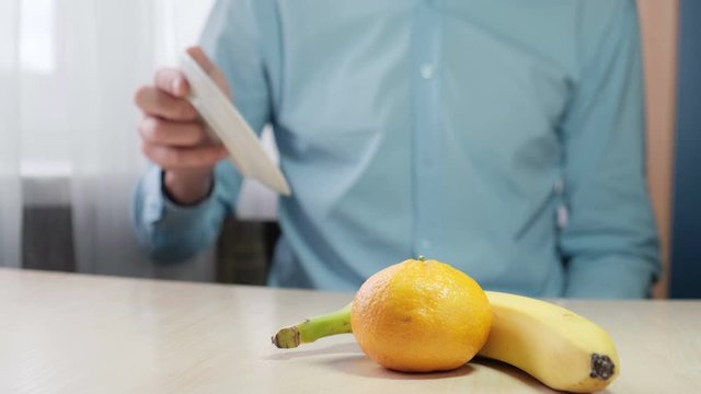 Choosing a healthy diet. A man throws a cake and picks fresh fruit