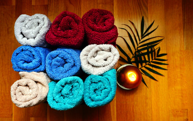 Obraz na płótnie Canvas Bath or wellness accessories, soft terry colorful towels stacked in a box on the wooden background