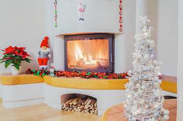 Christmas decorations in living room with burning fireplace 