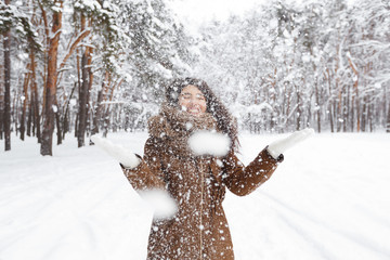 Cheerful Girl Throwing Snow Making Snowfall In Beautiful Forest