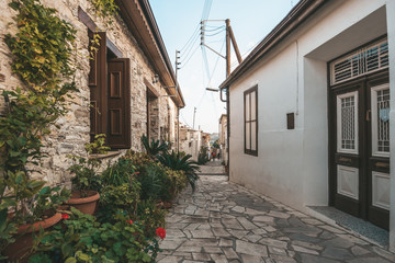 Fototapeta na wymiar Beautiful narrow street of Lefkara village, Cyprus with flower pots and masonry.