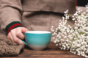 Fototapeta na wymiar Woman in warm sweater drinking a hot tea close up background.
