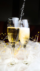 Ein paar Champagnergläser werden an Silvester Neujahr 2026 eingeschenkt. 