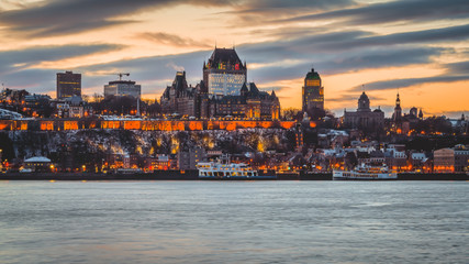 Cityscape View of Old Quebec City with Historic Chateau Frontenac and Ferry Boat on the Saint Lawrence River at Dusk Sunset