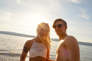 Fototapeta premium Portrait Of Beautiful Smiling Young Man And Woman At Beach