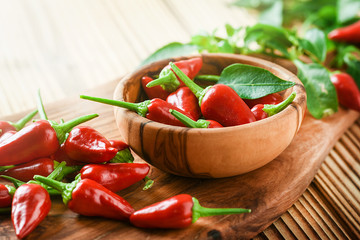 Hot chili peppers in bowl on rustic old table. Red pepper close up or detail.