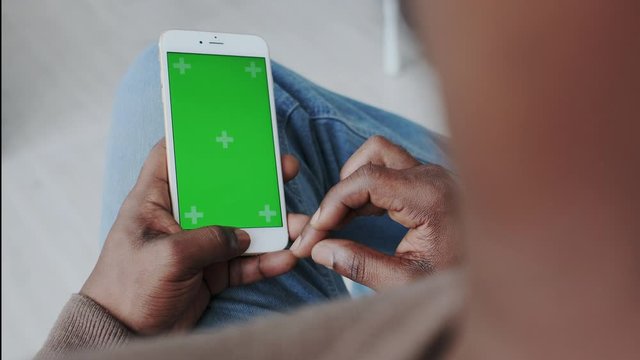 Green Screen or Mock Up Display on Mobile Phone. African American Man with Smartphone at Home. Watching Ad Content or Instagram Timeline, Surfing Web, Sharing Social Media.
