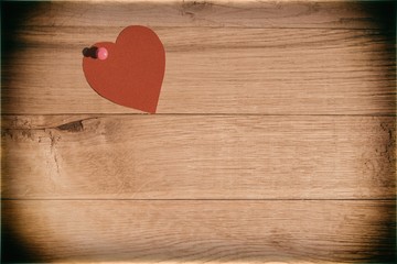 heart of cardboard pin attached to a wooden background