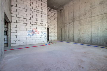 Unfinished construction empty room. Walls from lightweight aggregate concrete blocks with empty...