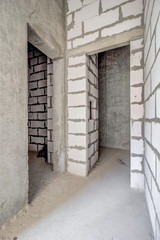 Unfinished construction empty room. Walls from lightweight aggregate concrete blocks with empty...