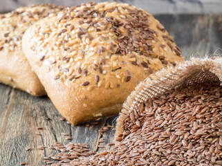 Flax seeds in linen and Bread with flax seeds  and sesame on a dark wooden table