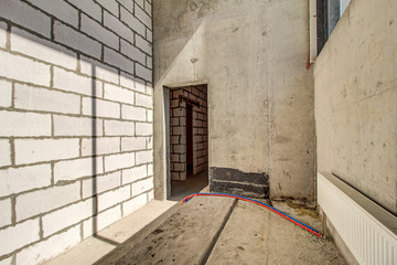 Unfinished construction empty room. Walls from lightweight aggregate concrete blocks with empty...