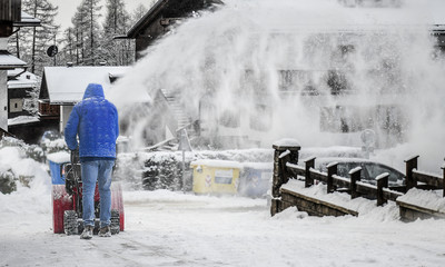 A man removing snow from street with snowblower.
