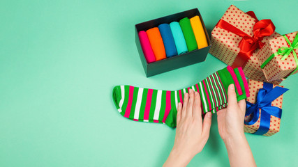 Fototapeta na wymiar Colorful collection of cotton socks as a gift in woman hands.