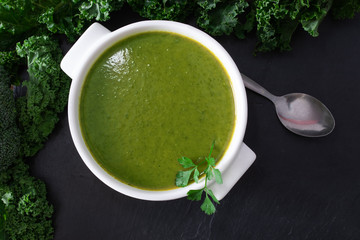 broth or cream of natural vegetables on the plate on black stone background